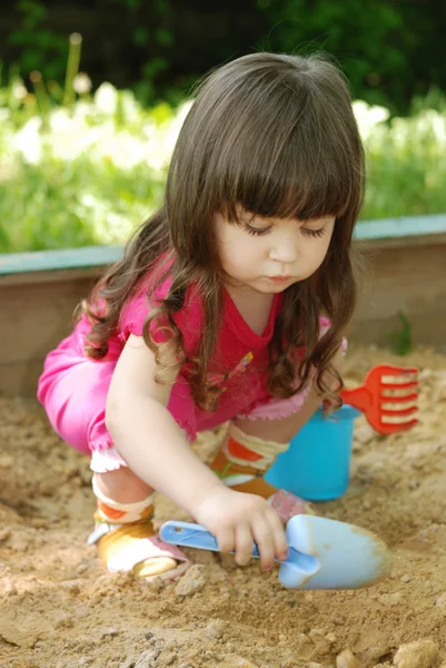 Девушка играет в песочницу — стоковое фото