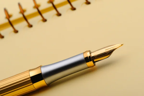 Fountain pen on a yellow notebook — Stock Photo, Image