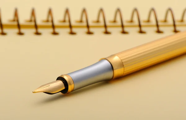 Фонтанна ручка на жовтому блокноті — стокове фото