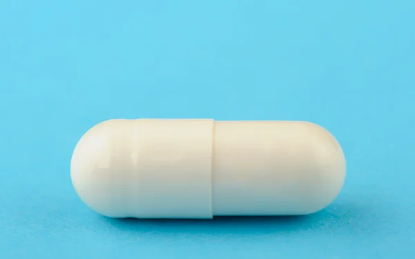 Weiße Tablette auf blauem Hintergrund. — Stockfoto