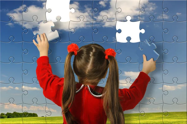 女の子は、大きなパズルを組み立てる — ストック写真