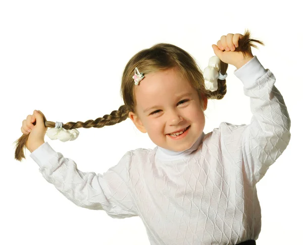 Маленькая девочка держит косички за руки — стоковое фото