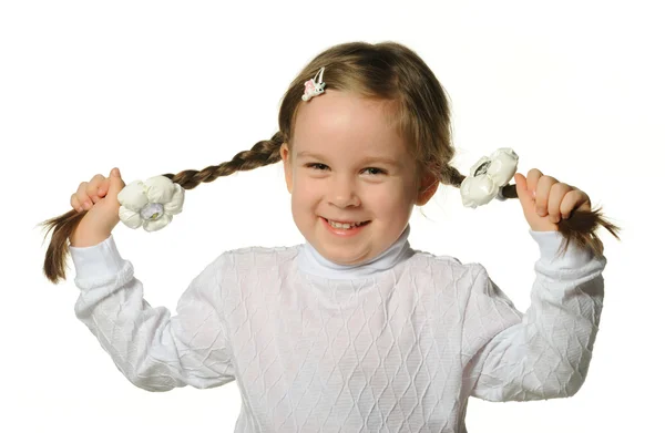 Маленькая девочка держит косички за руки — стоковое фото