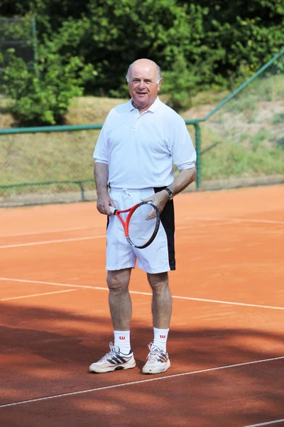 Um sênior aktive está jogando tênis — Fotografia de Stock