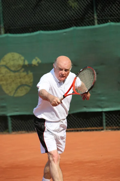 En aktive senior spelar tennis — Stockfoto
