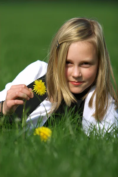 Blond meisje ligt in het gras — Stockfoto
