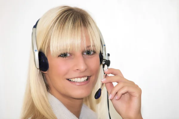 Kobiety młode, uśmiechnięte z zestawu słuchawkowego — Zdjęcie stockowe