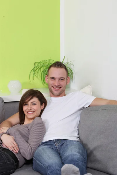 Jovem, feliz casal relaxante em casa . — Fotografia de Stock