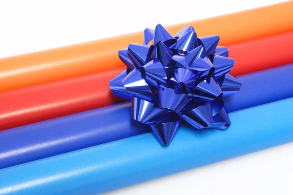 Papel de embalaje colorido y un arco de regalo — Foto de Stock