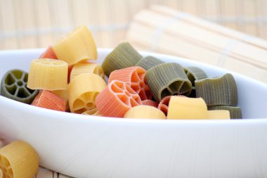 some italian pasta in orange, yellow and green