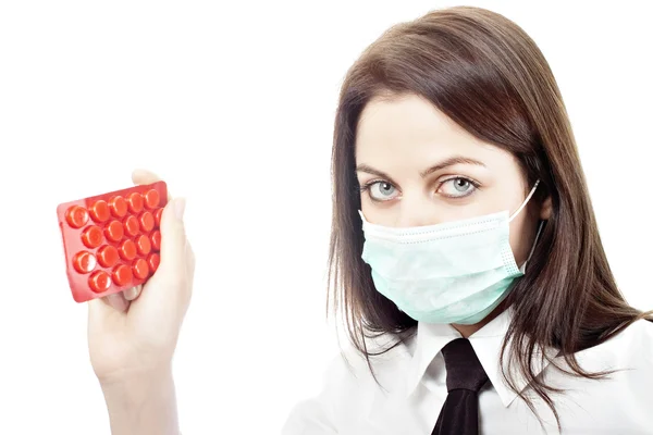 Meisje in griep masker met tabletten — Stockfoto