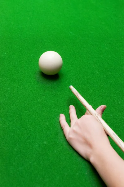 Hand with pool cue on baize — Stock Photo, Image