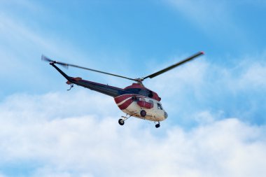 Helicopter against blue sky clipart