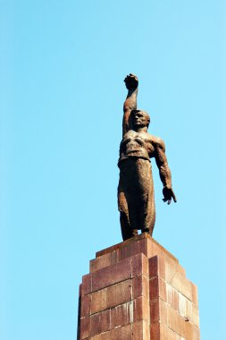 Bronze statue of soviet working man with clenched fist clipart