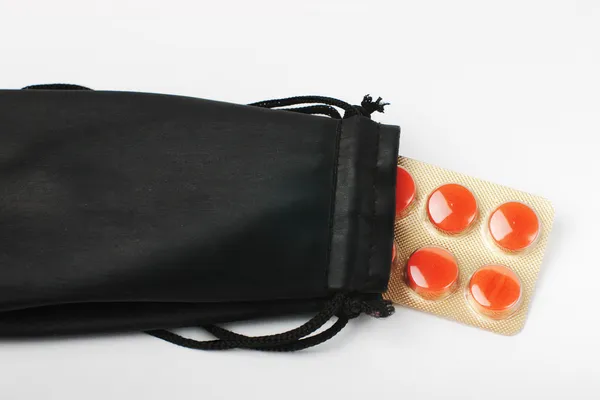Pílulas vermelhas dentro da bolsa preta — Fotografia de Stock