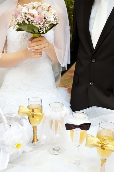 Bride with groom near table with glasses — Stock Photo, Image