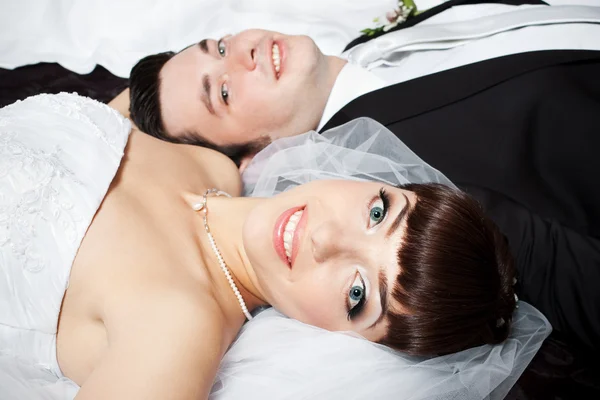 Lächelnde Braut liegt mit verschwommenem Bräutigam-Gesicht — Stockfoto