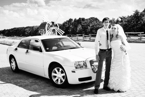 Noiva e noivo com um carro branco — Fotografia de Stock