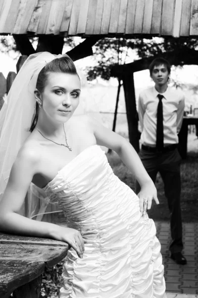 Nevěsta v bílém závoji s rozmazané ženicha — Stock fotografie