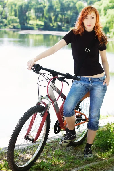 stock image Girl in blue jeans with bicycle