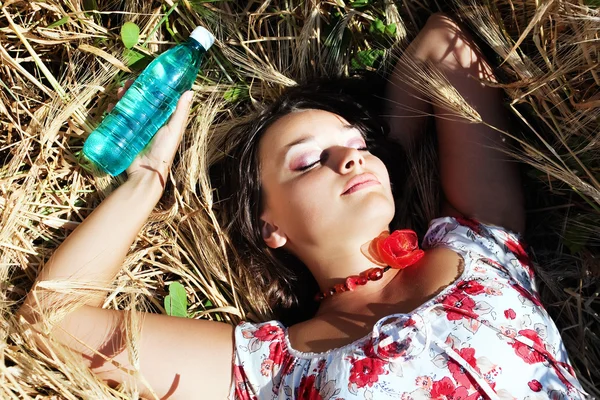 Menina bonita deitado com garrafa de água — Fotografia de Stock