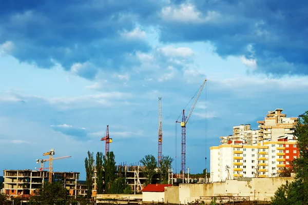 Residential building site with cranes and stormy clouds — Stock Photo, Image