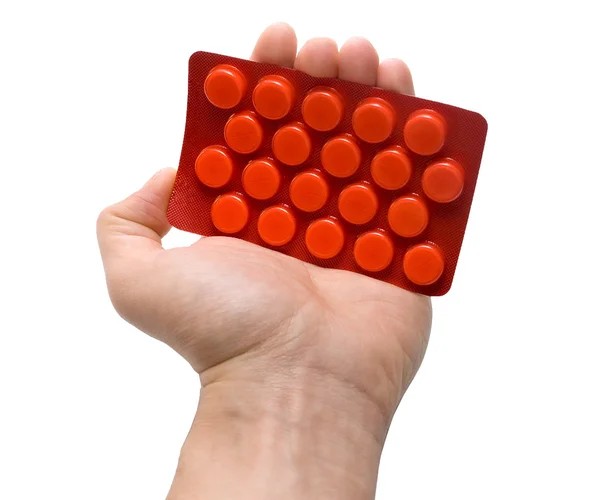 Embalagem de mão com comprimidos vermelhos — Fotografia de Stock