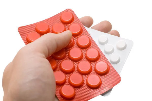 Mão segurando uma pílulas vermelhas e brancas — Fotografia de Stock