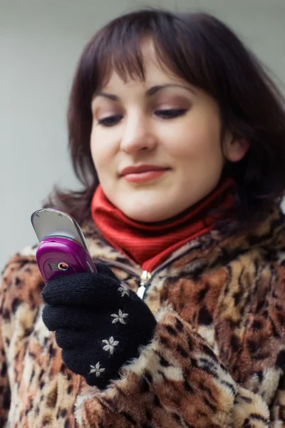 Meisje kijkt neer op een mobiele telefoon — Stockfoto