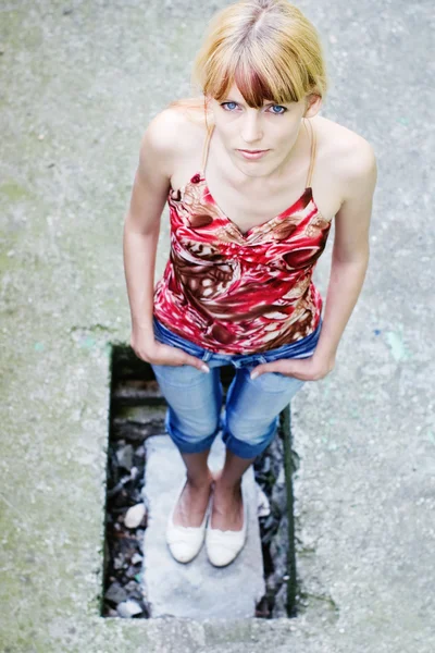 Blonde looking up from a pit in concrete — Stock Photo, Image
