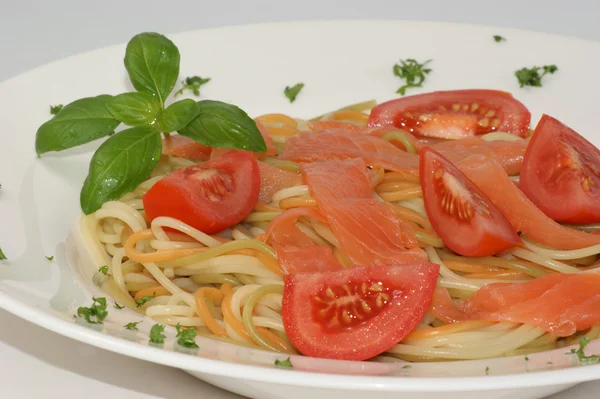 Tomato and colored spaghetti — Stock Photo, Image