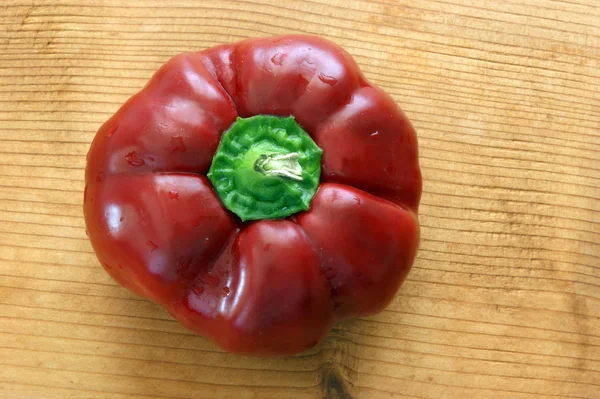 Organické červenou papriku na dřevěné desce — Stock fotografie
