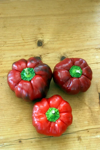 Органический красный перец на деревянной доске — стоковое фото