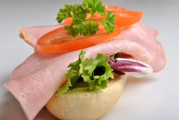 Bread roll with ham and tomato — Stock Photo, Image