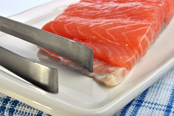 Salmon fillet and a tongs — Stock Photo, Image