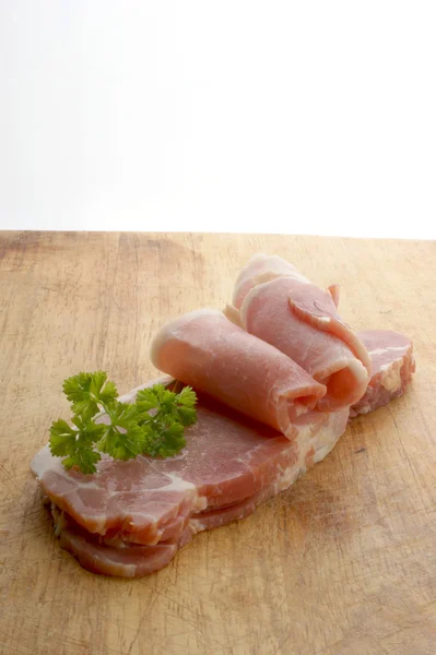 Rolled raw bacon, organic tomato — Stock Photo, Image