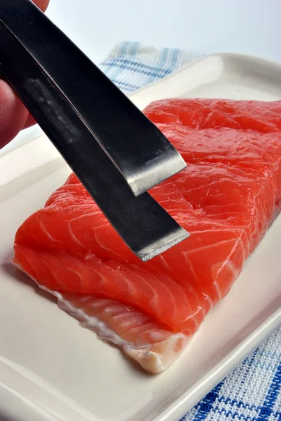 Salmon fillet and a tongs — Stock Photo, Image
