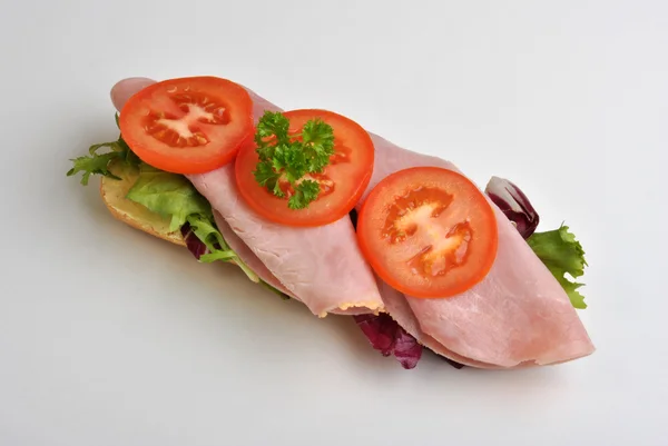 Bread roll with ham and tomato — Stock Photo, Image