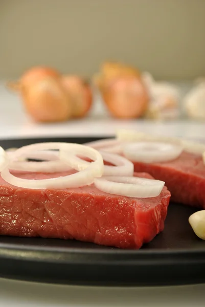Raw organic steak with onion — Stock Photo, Image