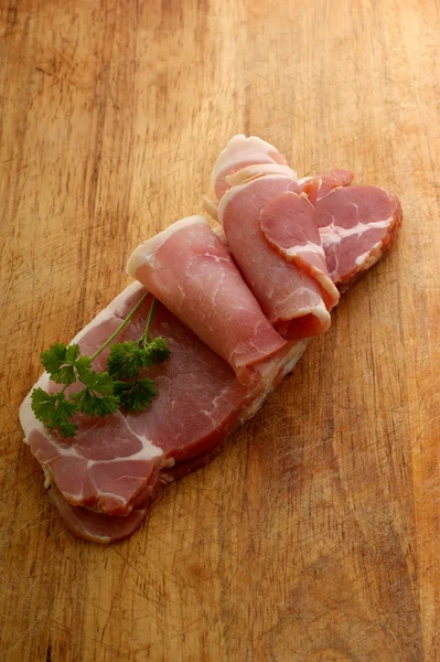 Smoked bacon on a timber board — Stock Photo, Image