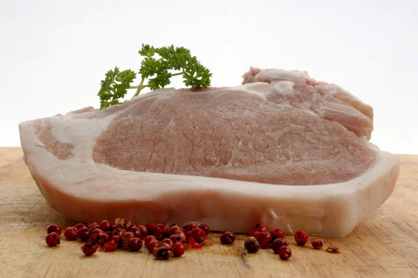 Ein rohes Bio-Schweinekotelett und Petersilie — Stockfoto