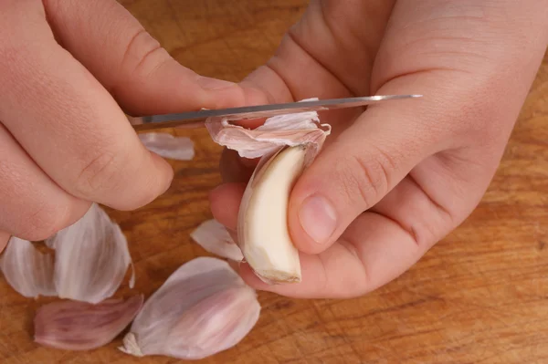 Tagliare e sbucciare aglio e due mani — Foto Stock