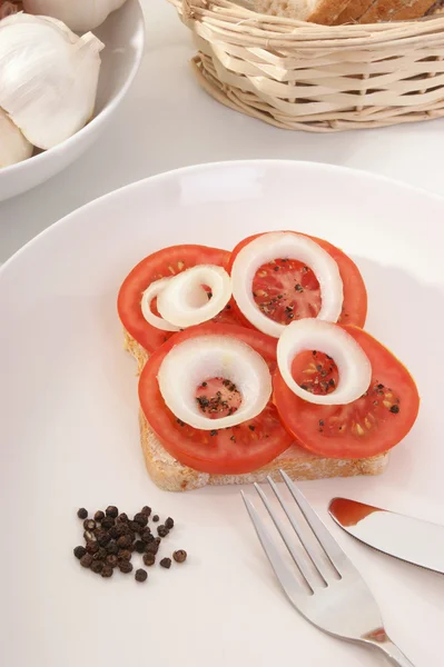 Tomate cortado em parte em um pão — Fotografia de Stock