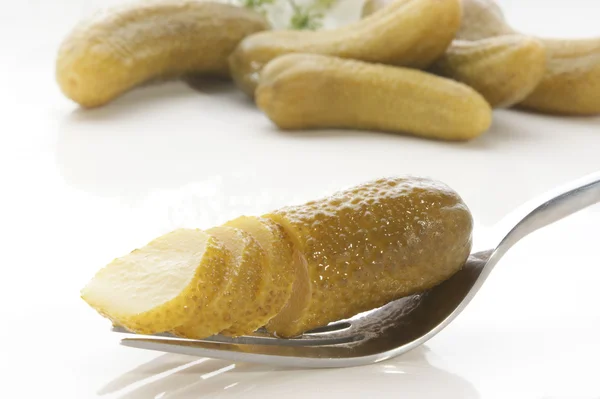 Gherkin cut into slices on a fork — Stock Photo, Image