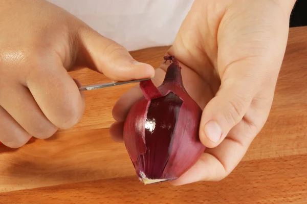 Peel one organic red onion — Stock Photo, Image