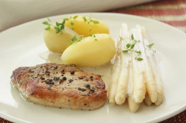 Costeleta de porco com batata e espargos — Fotografia de Stock