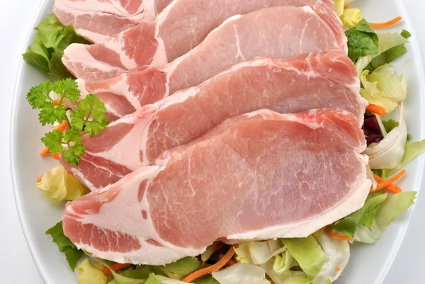 Сырая органическая свинина на тарелке — стоковое фото