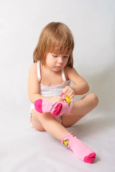 Μικρό κορίτσι βάζει σε τις κάλτσες — Φωτογραφία Αρχείου