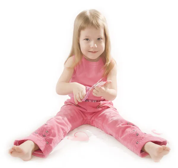 Kleines Mädchen schneidet Papier Herzform — Stockfoto