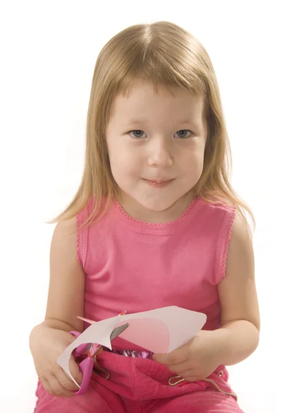 Klein meisje is snijden papier hart vorm — Stockfoto
